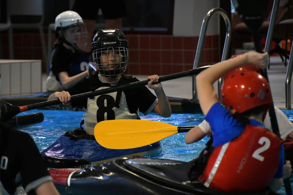 tre personer i kajakk som spiller polo